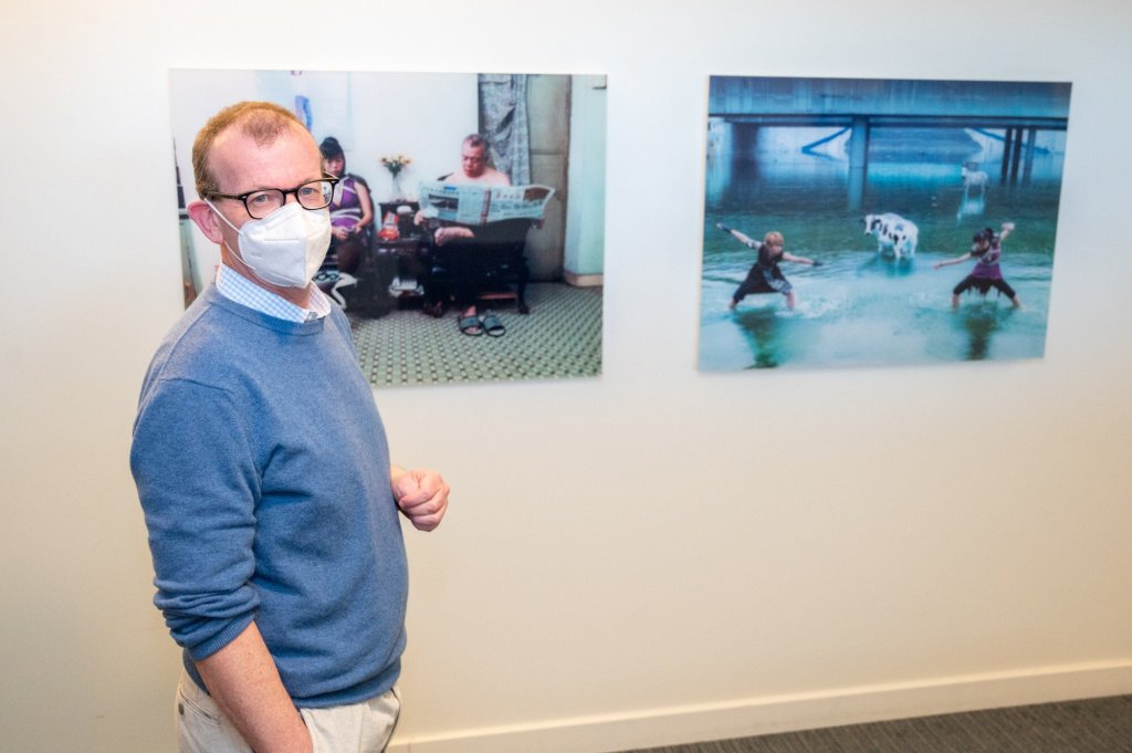 自身の写真作品の前に立つ、シカゴの経済学者であり、アーティストでもあるカニス・プレンダーガスト