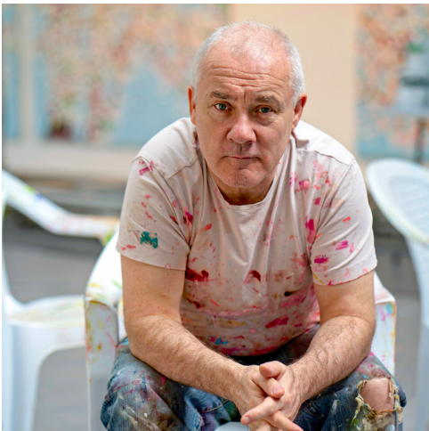 椅子に腰掛けるダミアン・ハースト